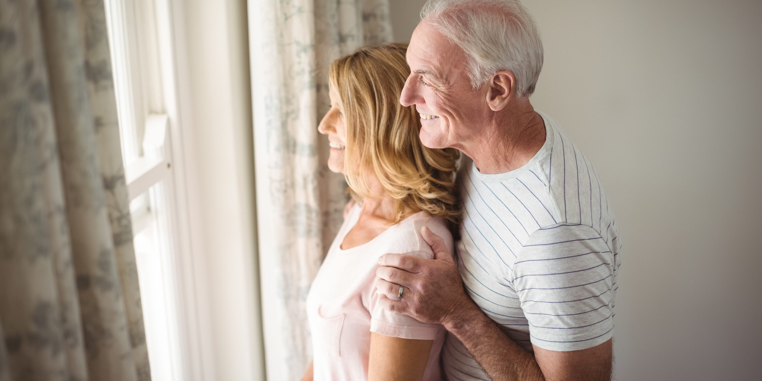Senior couple looking out from the window