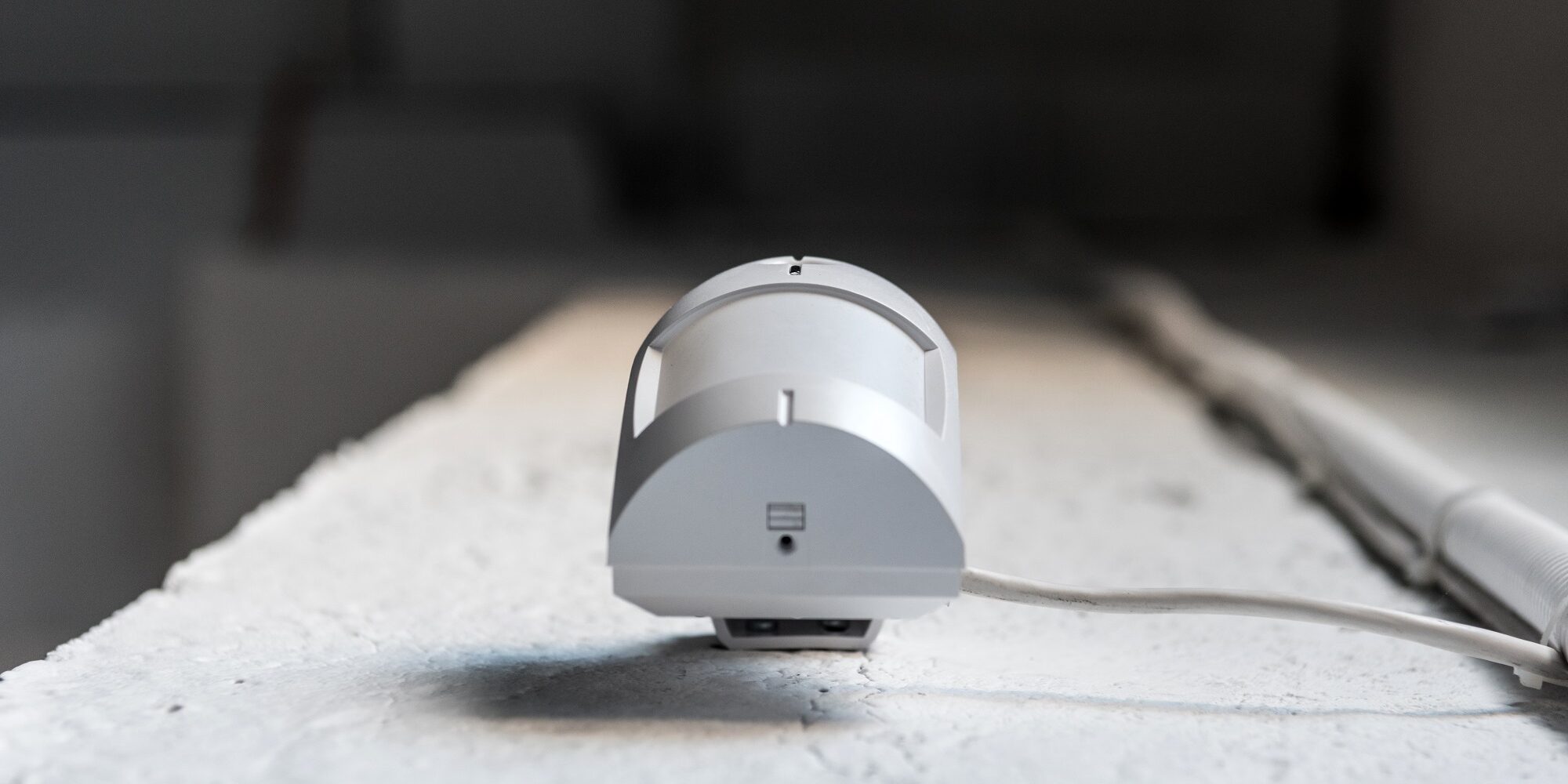 bottom view of one motion sensor on white wall