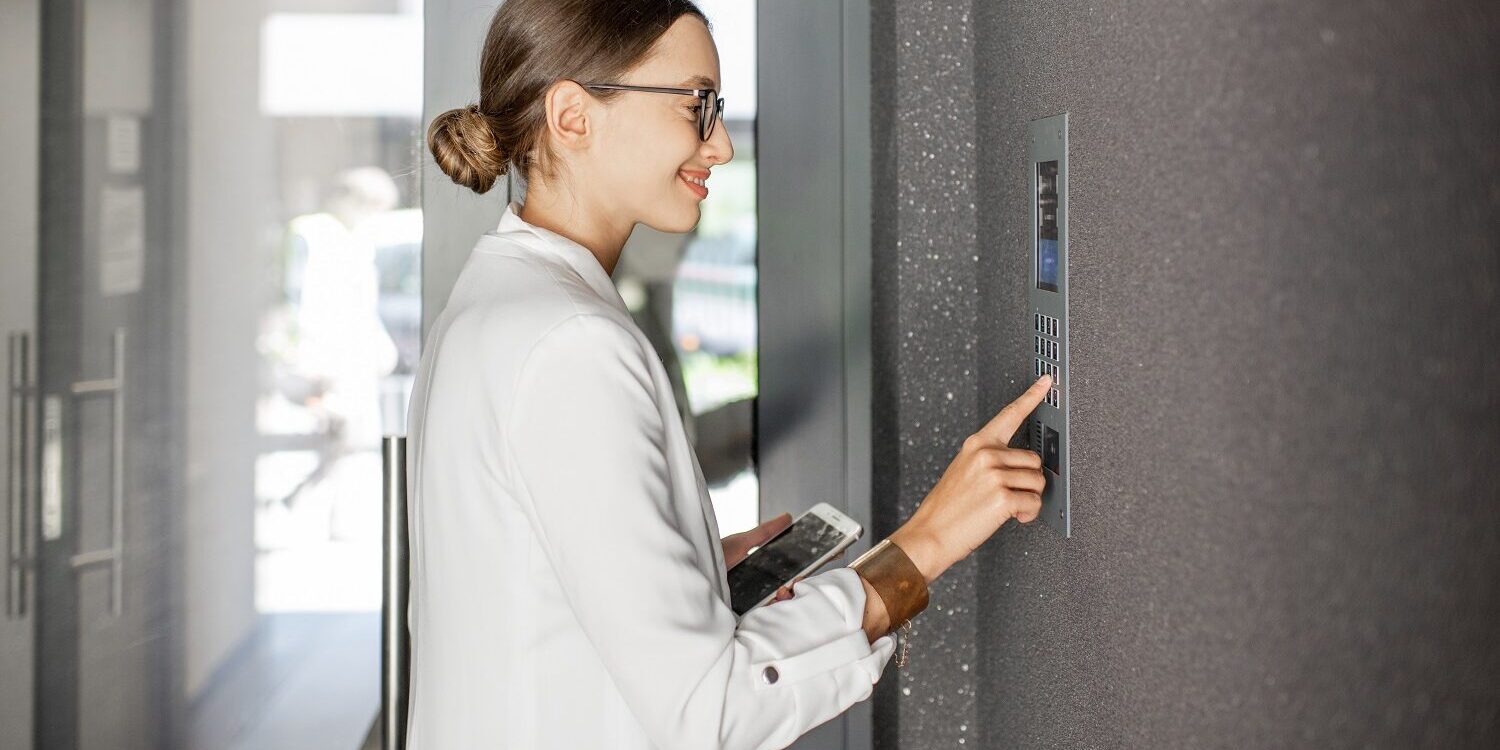 Woman entering code on the building entrance