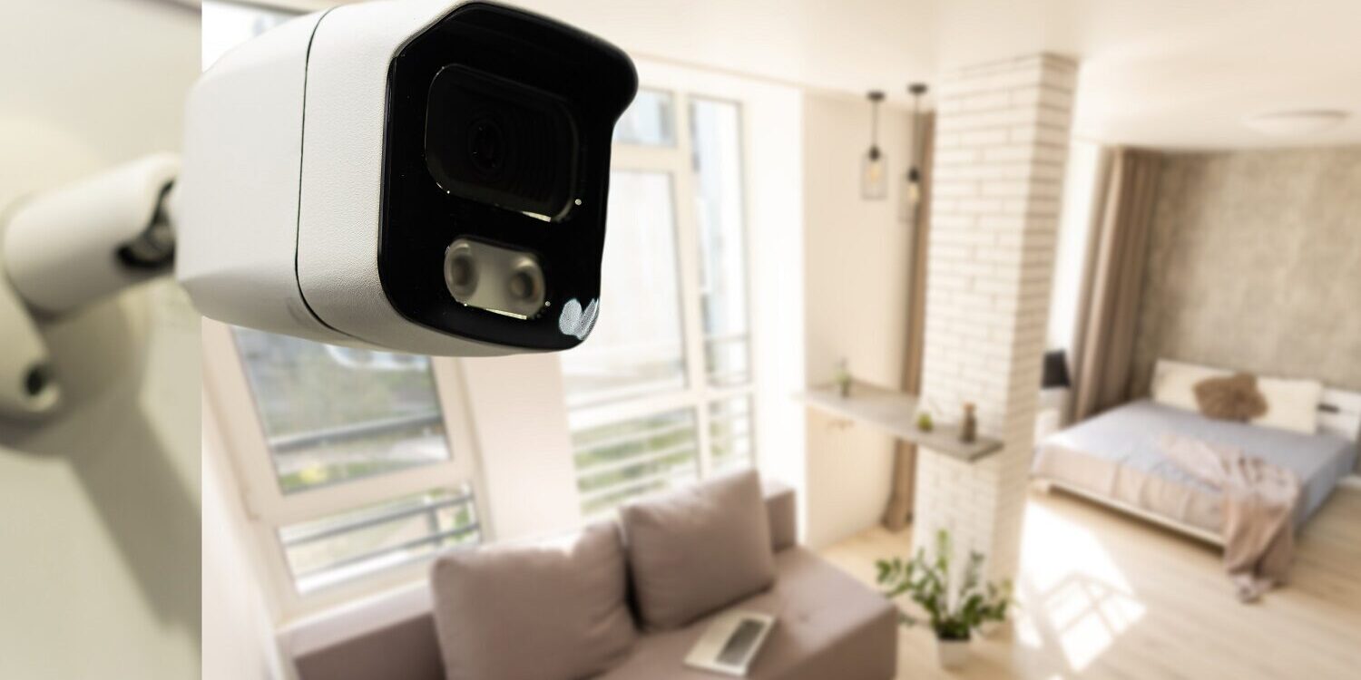 Close Up Object Shot of a Modern Wi-Fi Surveillance Camera on a White Wall in a Cozy Apartment Has Wi-Fi Icon Above it.