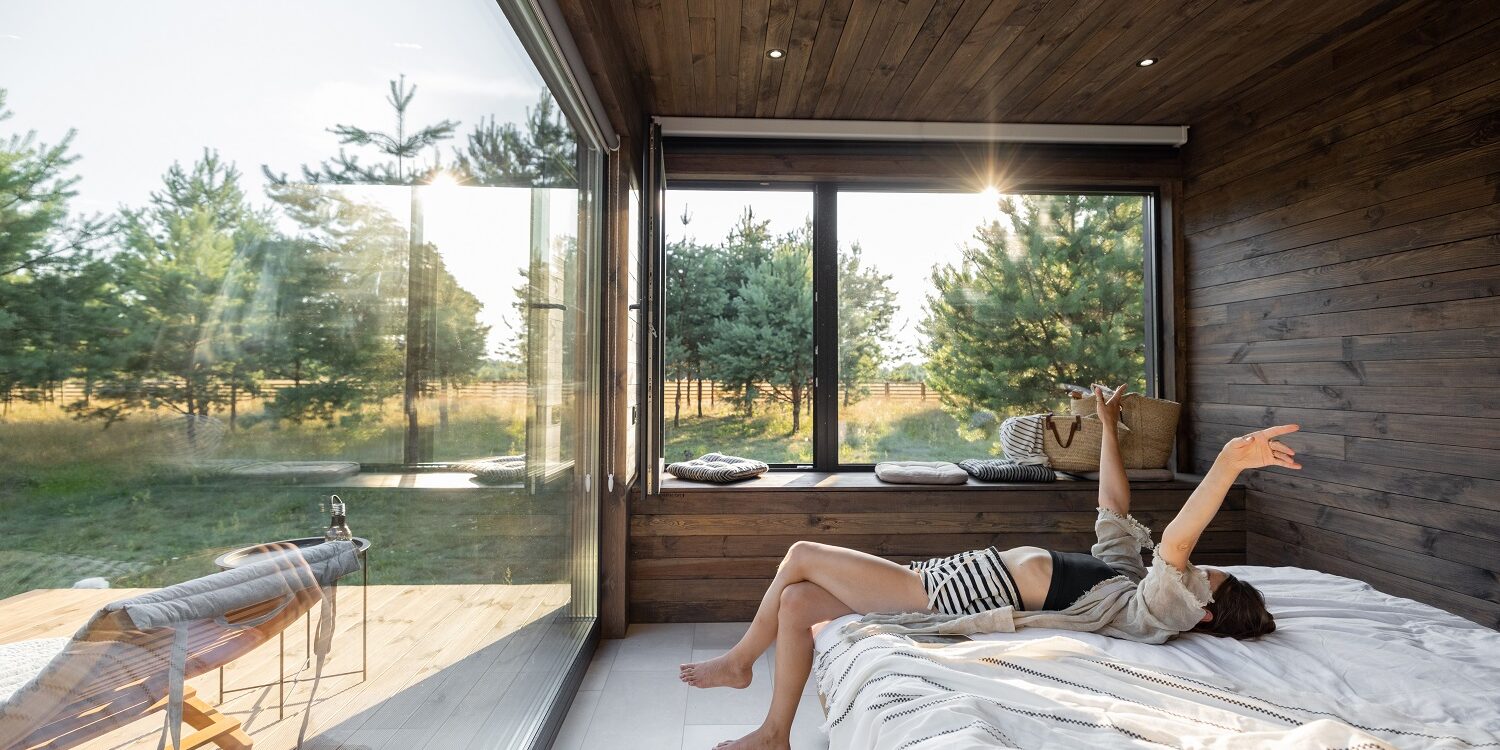 Woman wakes up at country house in nature