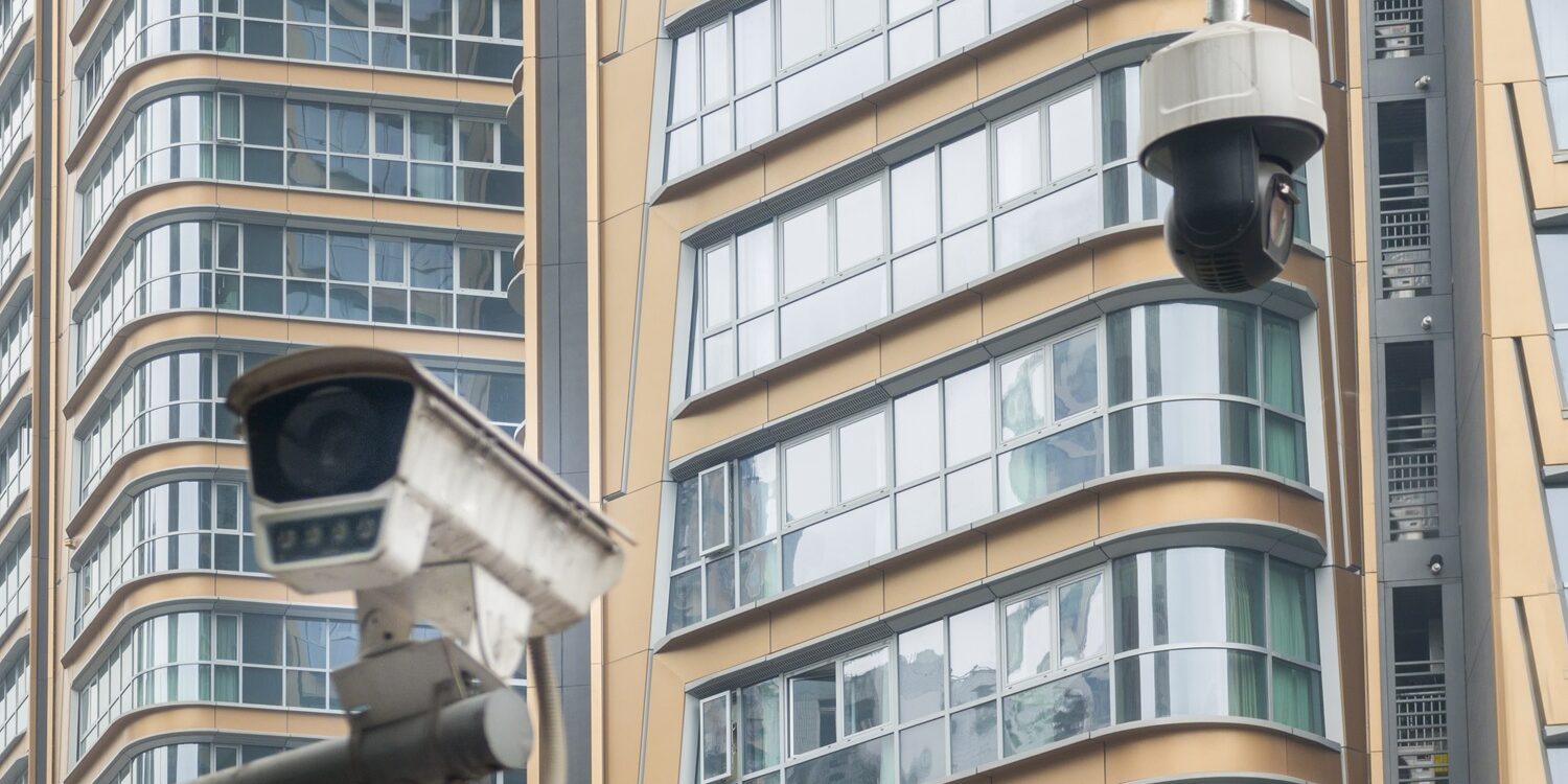 modern cctv camera hanging over modern residential building.