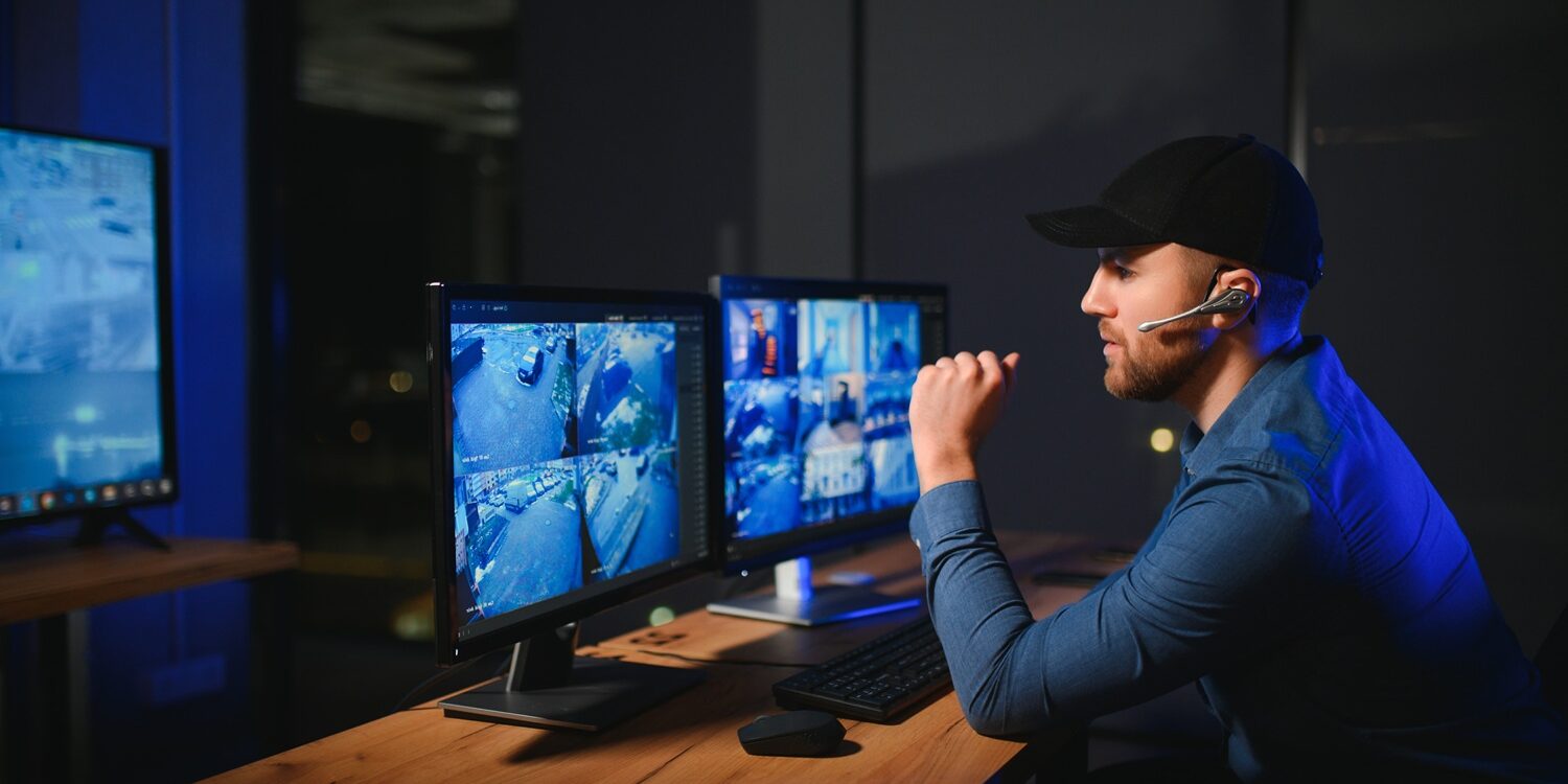 Male security guard monitoring modern CCTV cameras indoors